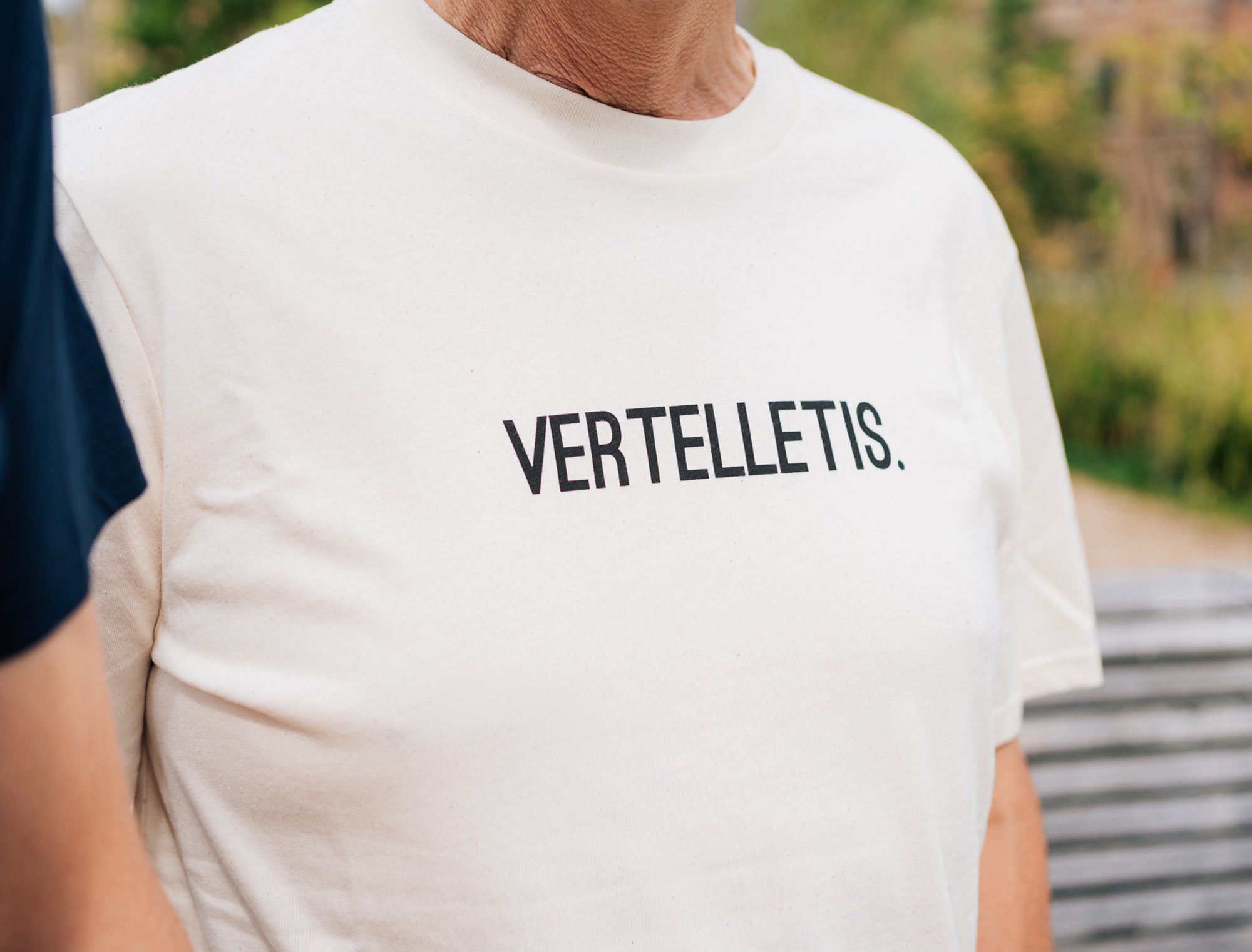 Close-up van een natural T-shirt met opdruk VERTELLETIS.