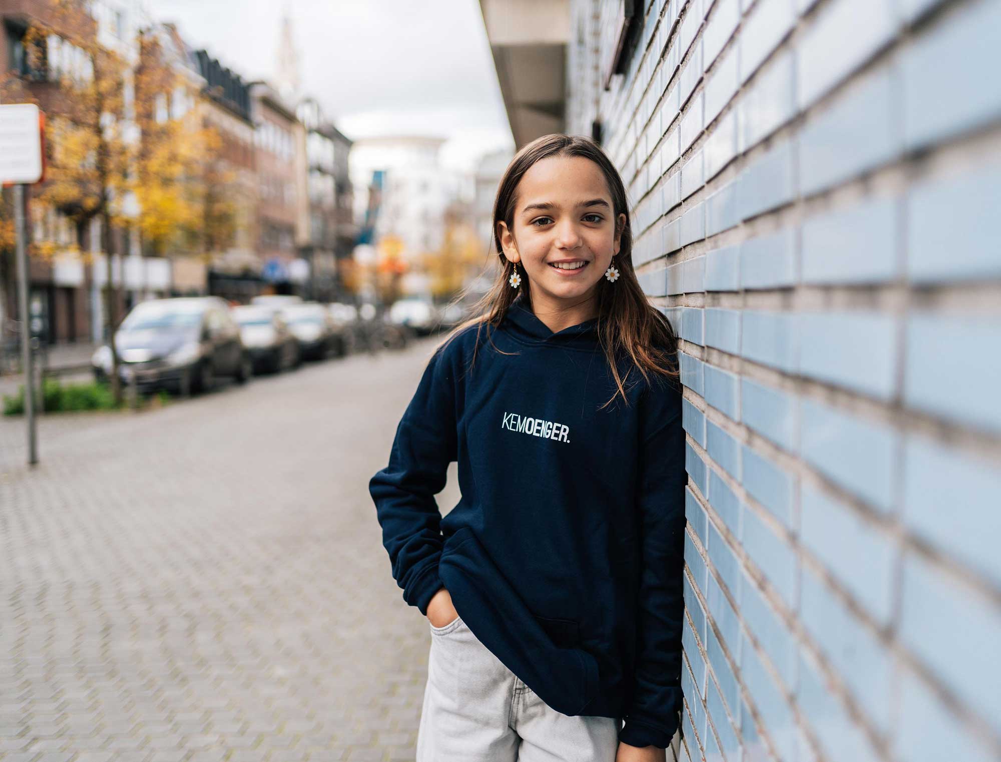 Meisje met blauwe hoodie met opdruk KEMOENGER.