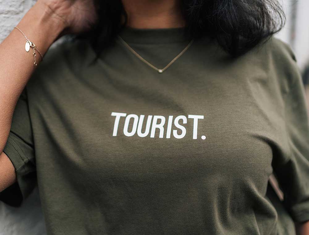 Close-up van een kaki T-shirt met opdruk TOURIST. voor volwassenen.