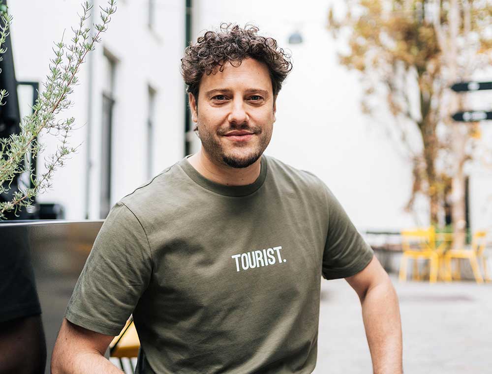 Man met een kaki T-shirt met opdruk TOURIST. voor volwassenen.
