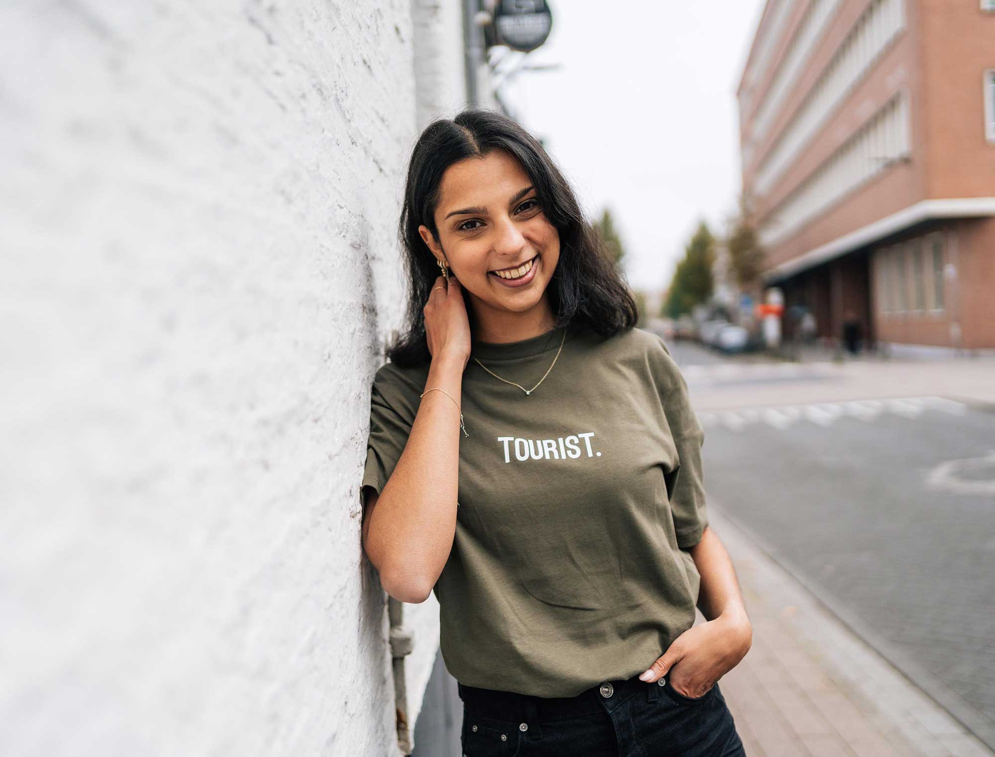 Vrouw met een kaki T-shirt met opdruk TOURIST. voor volwassenen.