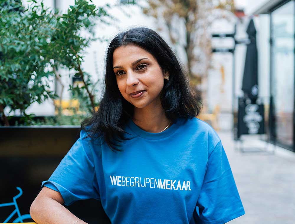 Vrouw met een blauwe T-shirt met opdruk WEBEGRIJPENMEKAAR.