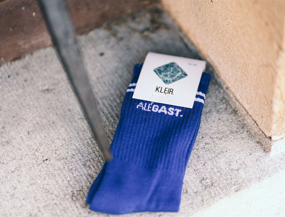 Blauwe sokken met opdruk ALEGAST. in verpakking.