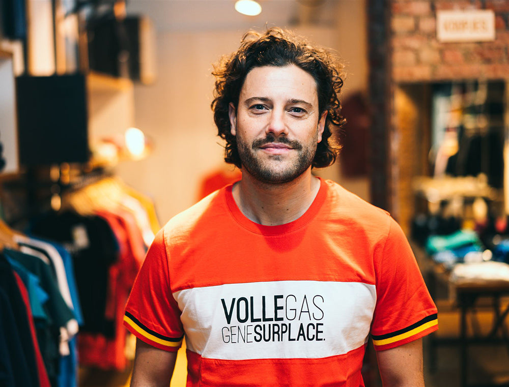 Man met rode T-shirt met opdruk VOLLEGASGENESURPLACE. 