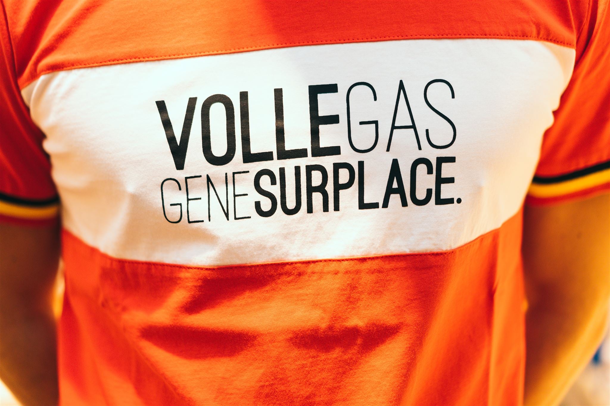 Close-up van rode T-shirt met opdruk VOLLEGASGENESURPLACE.