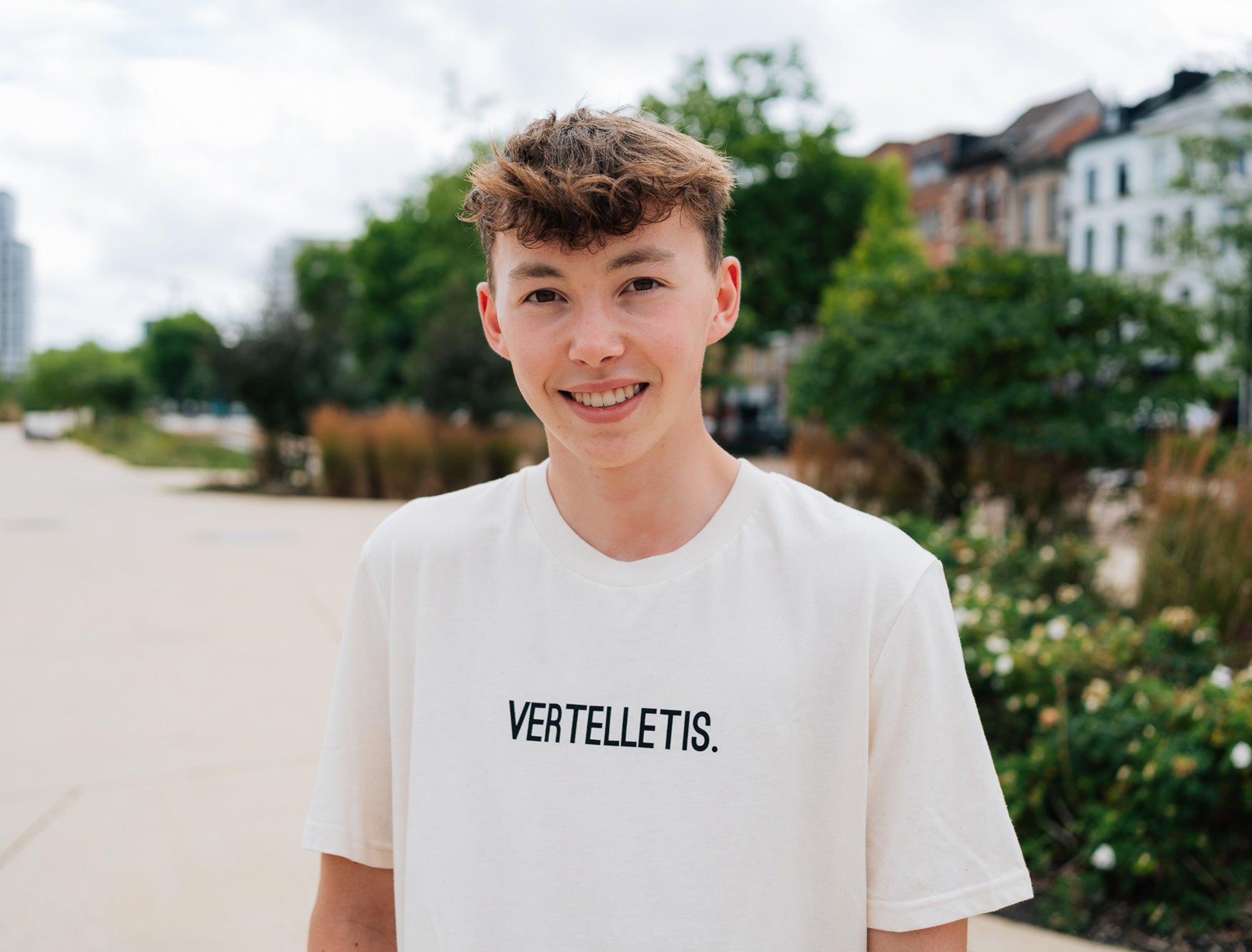 Jonge man met een natural T-shirt met opdruk VERTELLETIS.