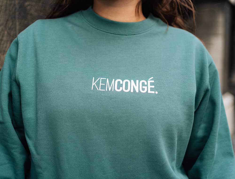 Vrouw met een groene sweater met opdruk KEMCONGE.