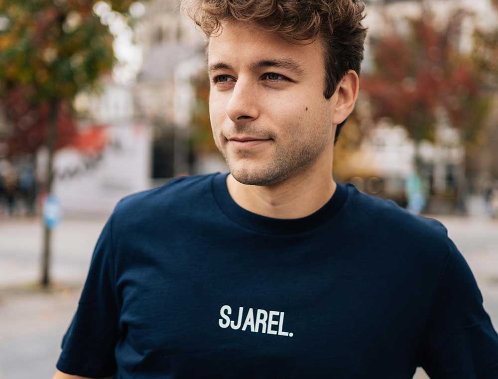 Man met een donkerblauwe T-shirt met opdruk SJAREL.