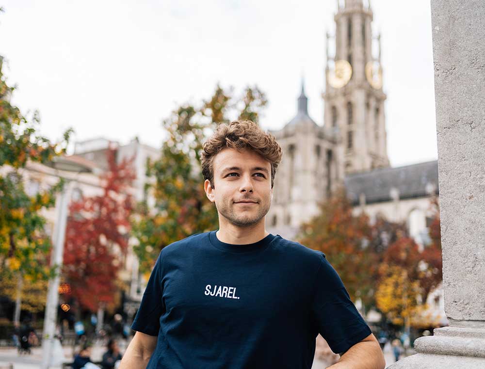 Man met een donkerblauwe T-shirt met opdruk SJAREL.