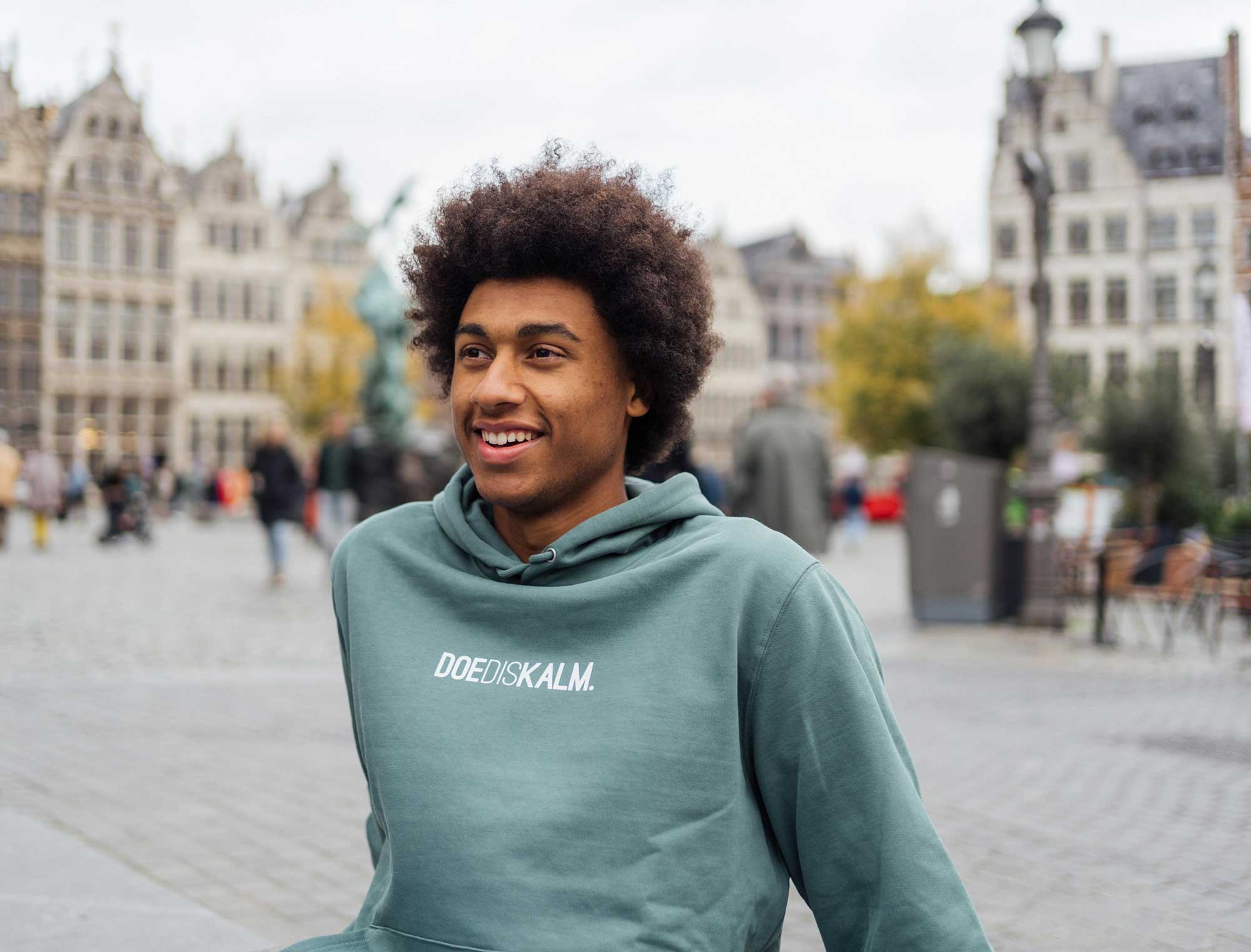Jongen met groene hoodie met opdruk DOEDISKALM.