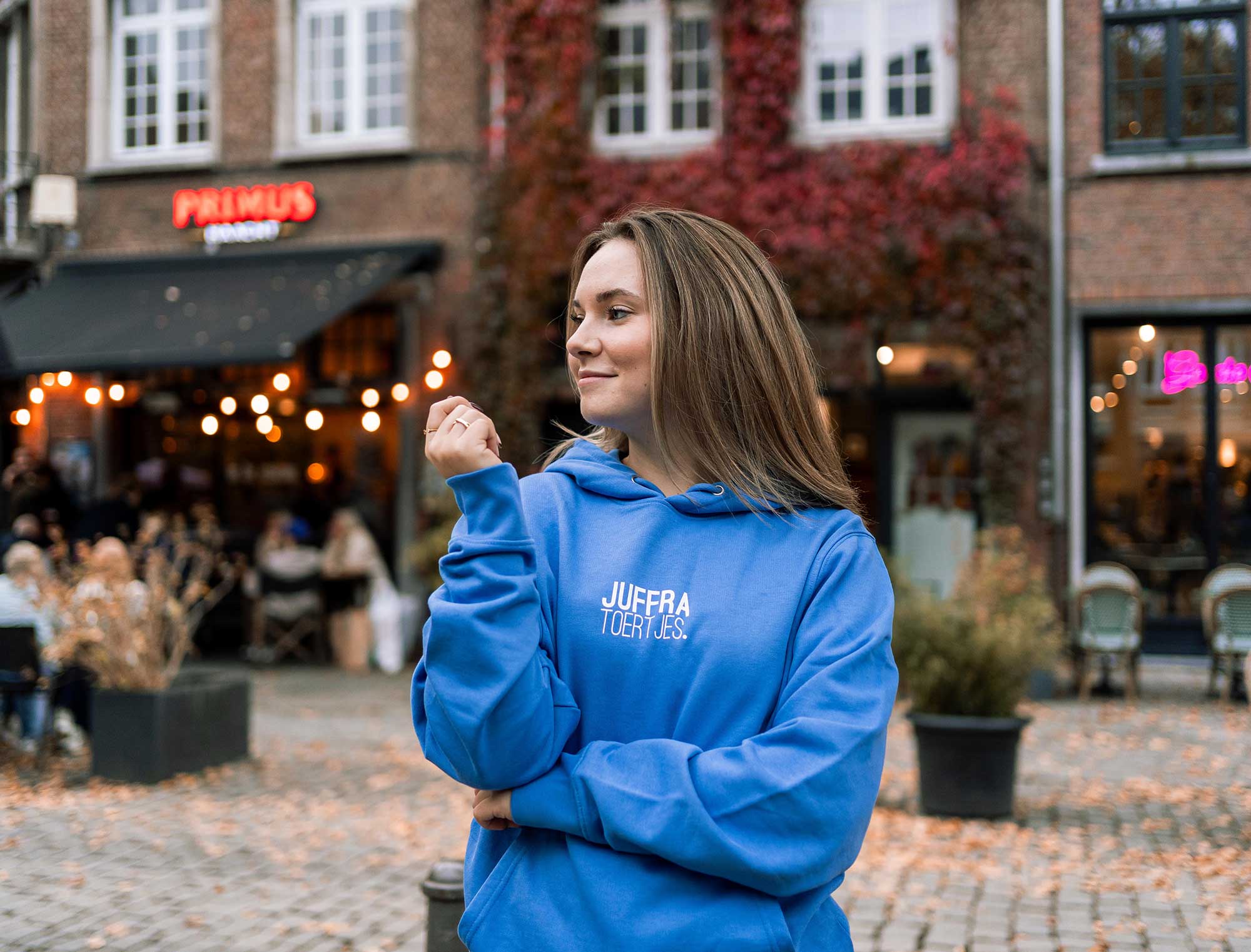 Vrouw met blauwe hoodie met opdruk JUFFRATOERTJES.
