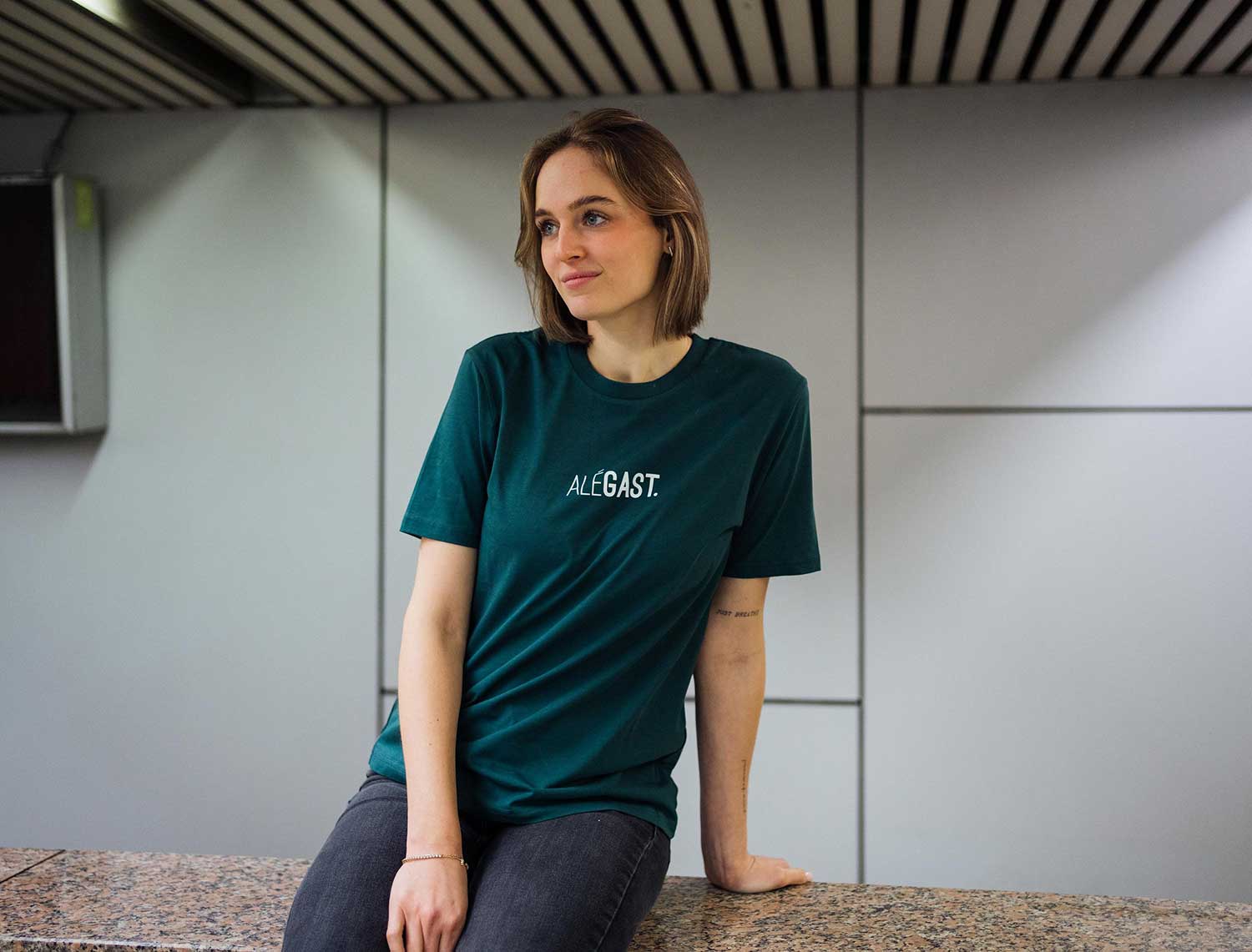 Vrouw met een groene T-shirt met opdruk ALEGAST.