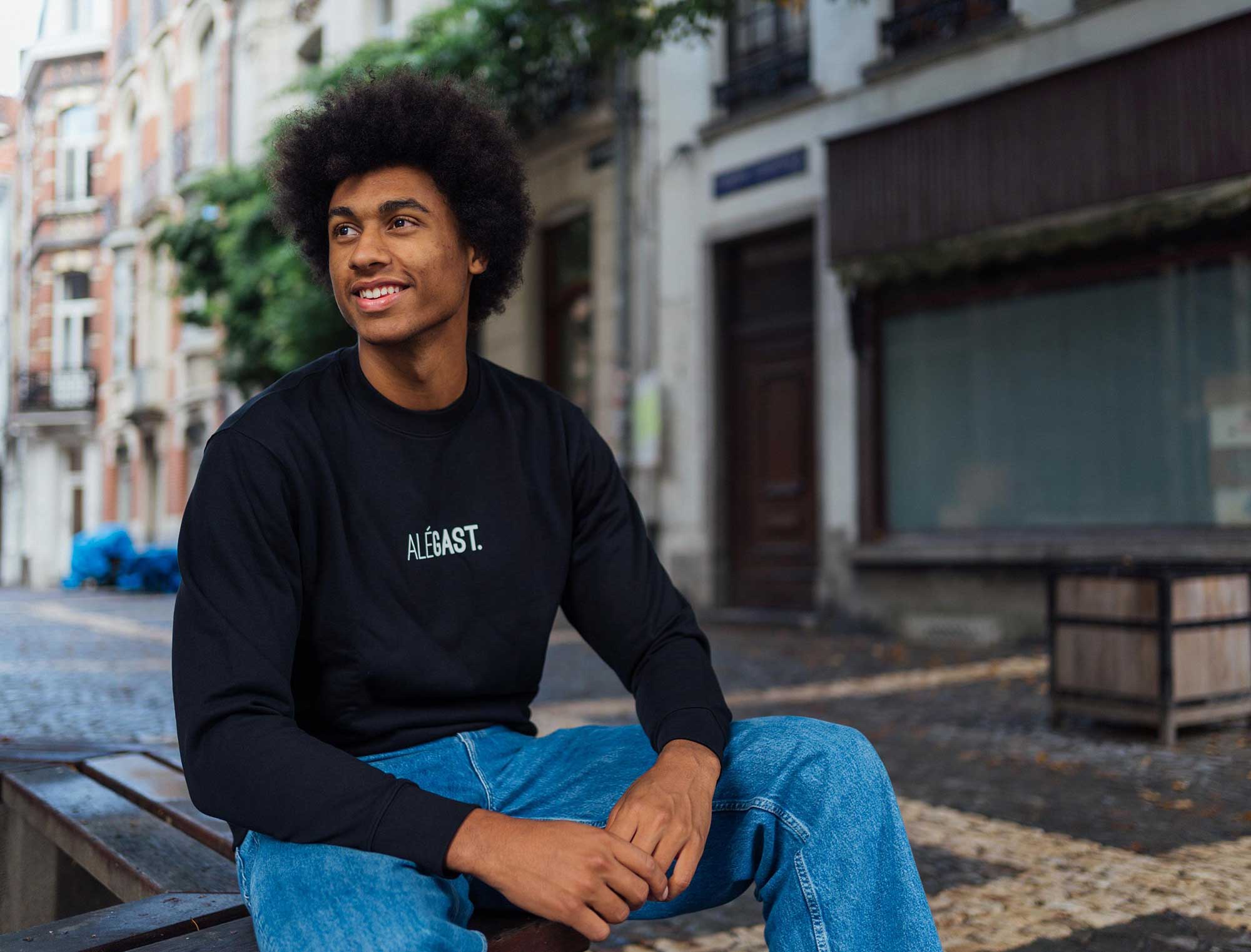 Man met een zwarte sweater met opdruk ALEGAST.