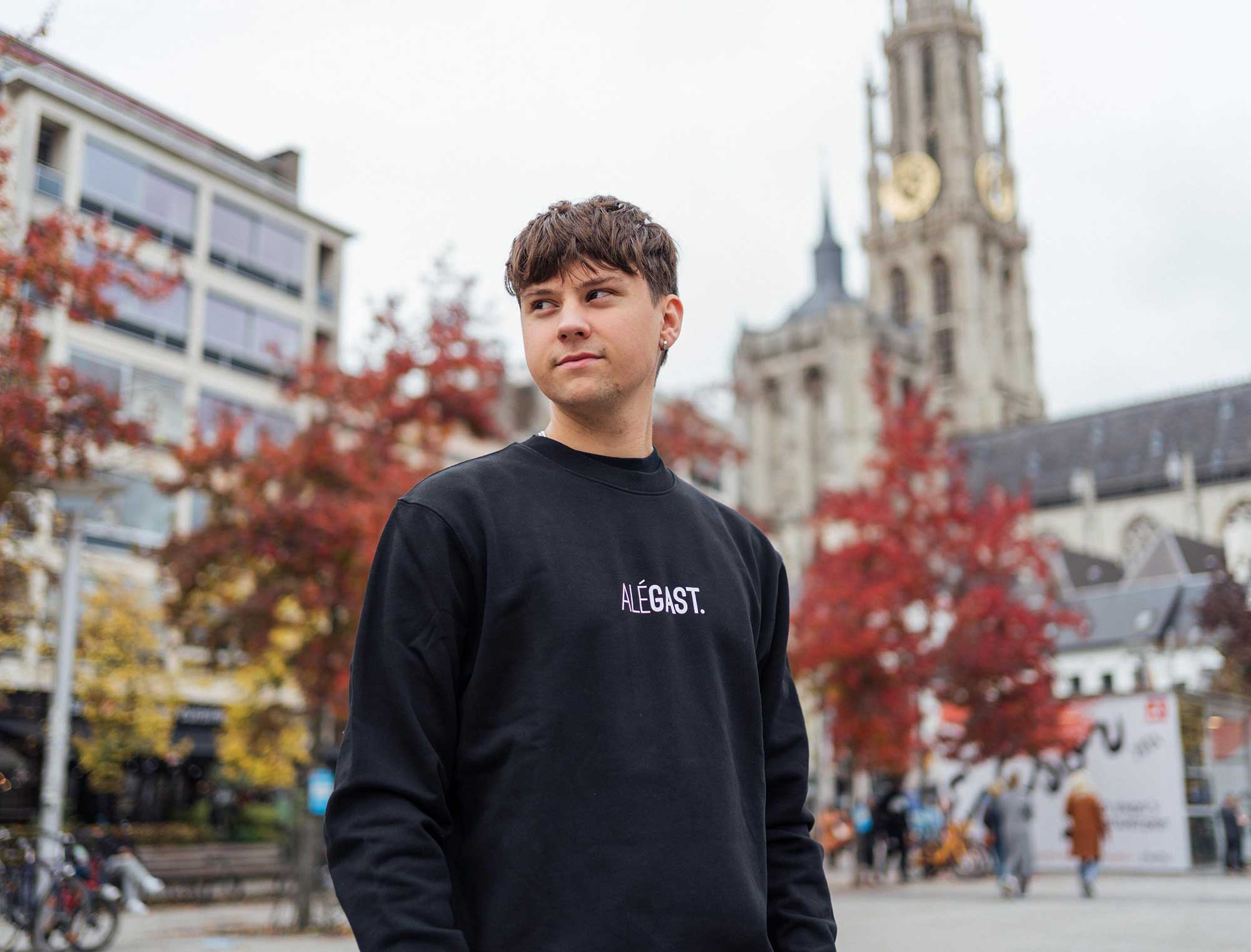 Man met een zwarte sweater met opdruk ALEGAST.
