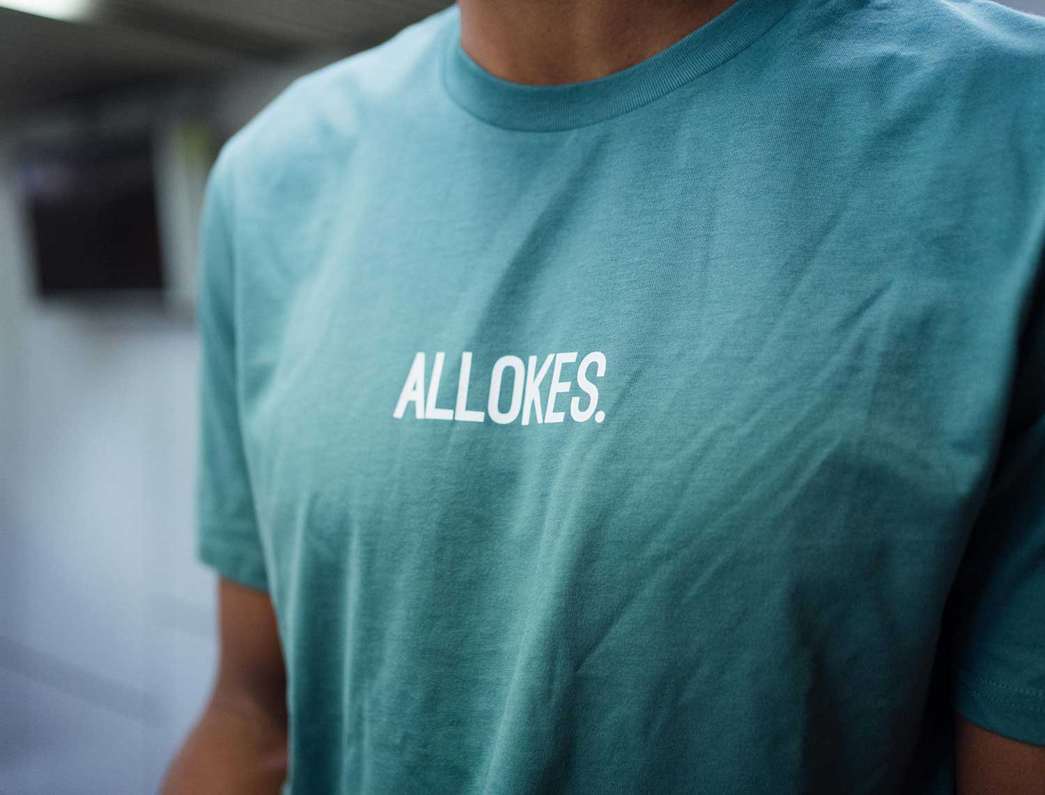 Close-up van een groene T-shirt met opdruk ALLOKES.