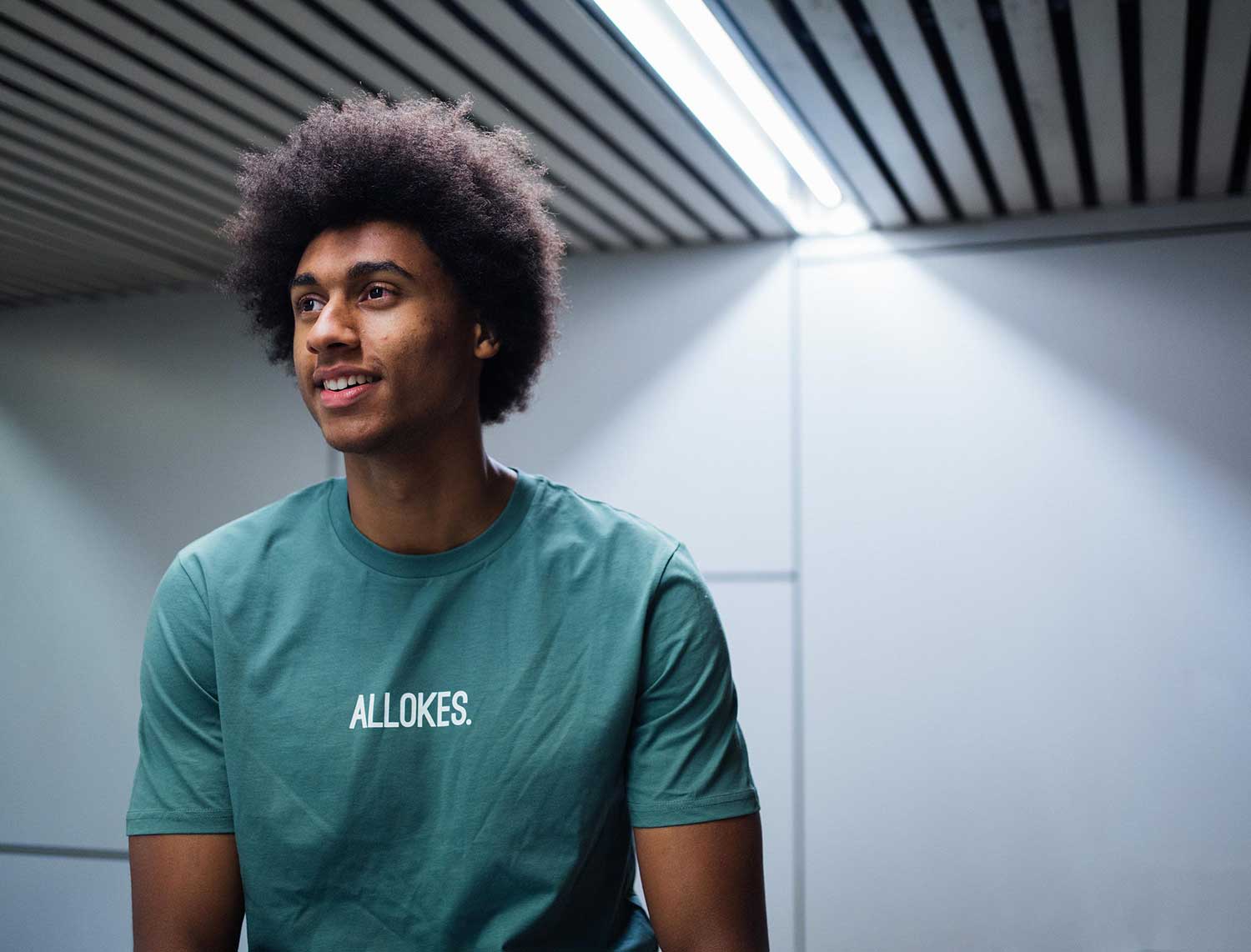 Man met een groene T-shirt met opdruk ALLOKES.
