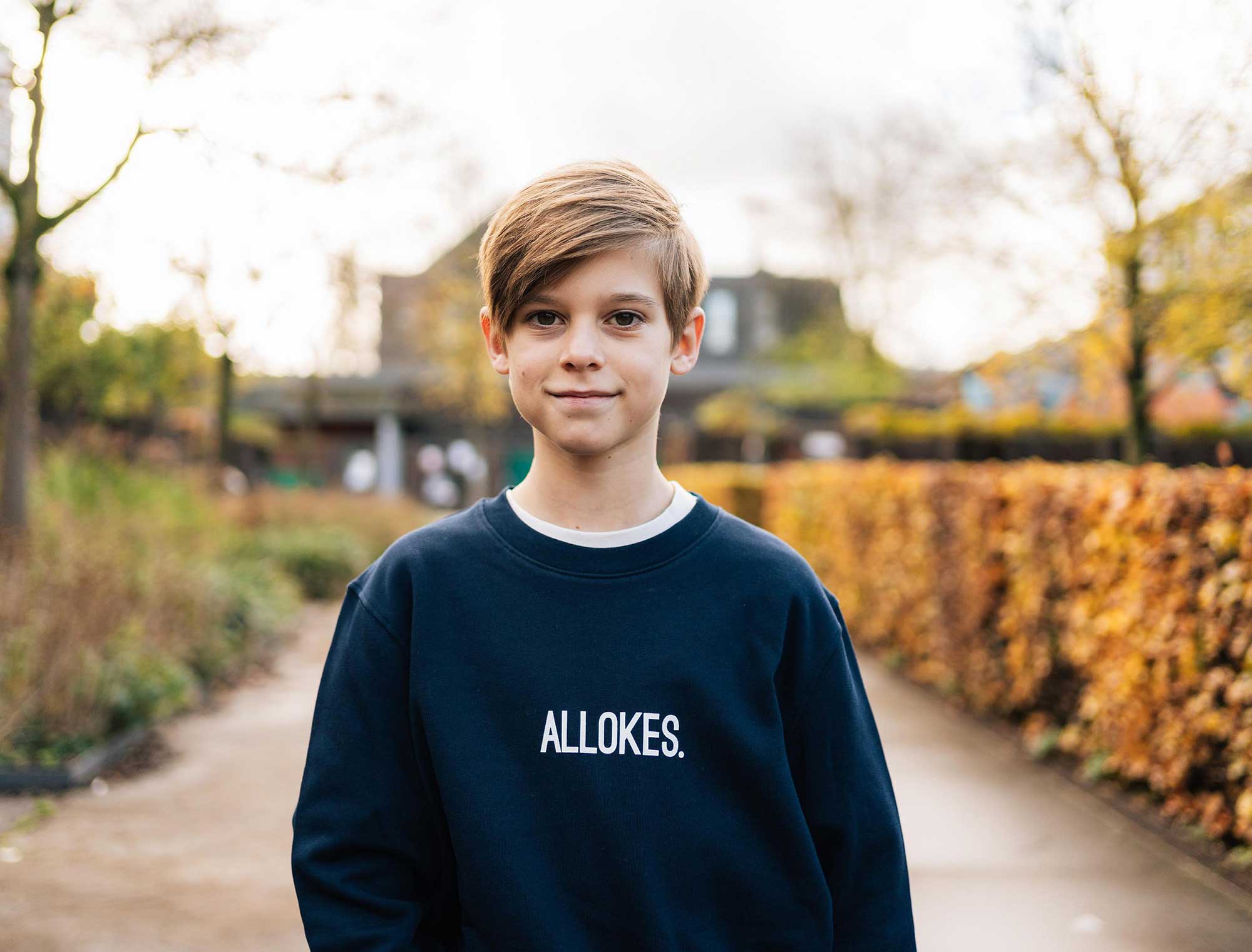 Jongen met een donkerblauwe sweater met opdruk ALLOKES. voor kinderen
