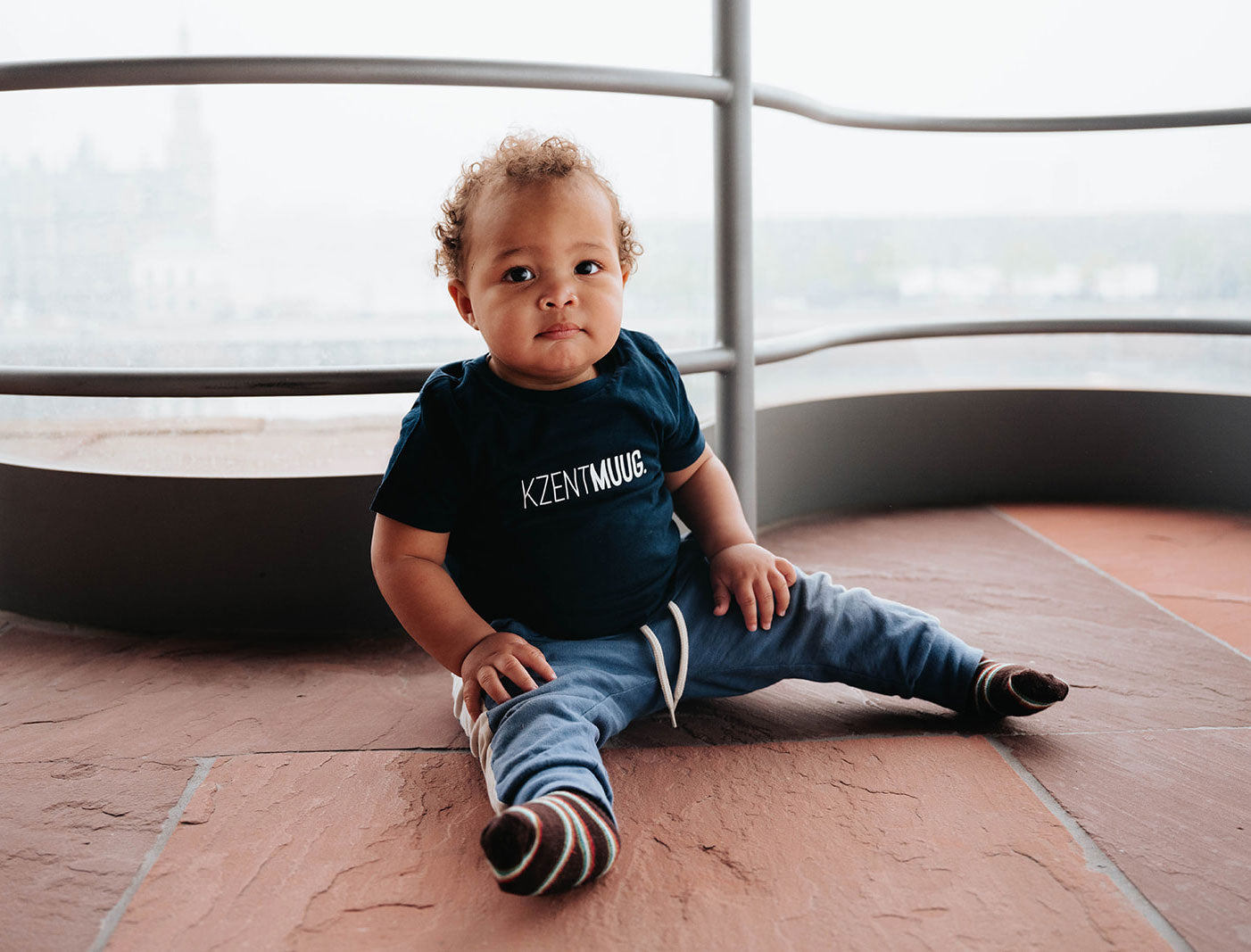 Jongen met een blauwe T-shirt voor baby's met opdruk KZENTMUUG.