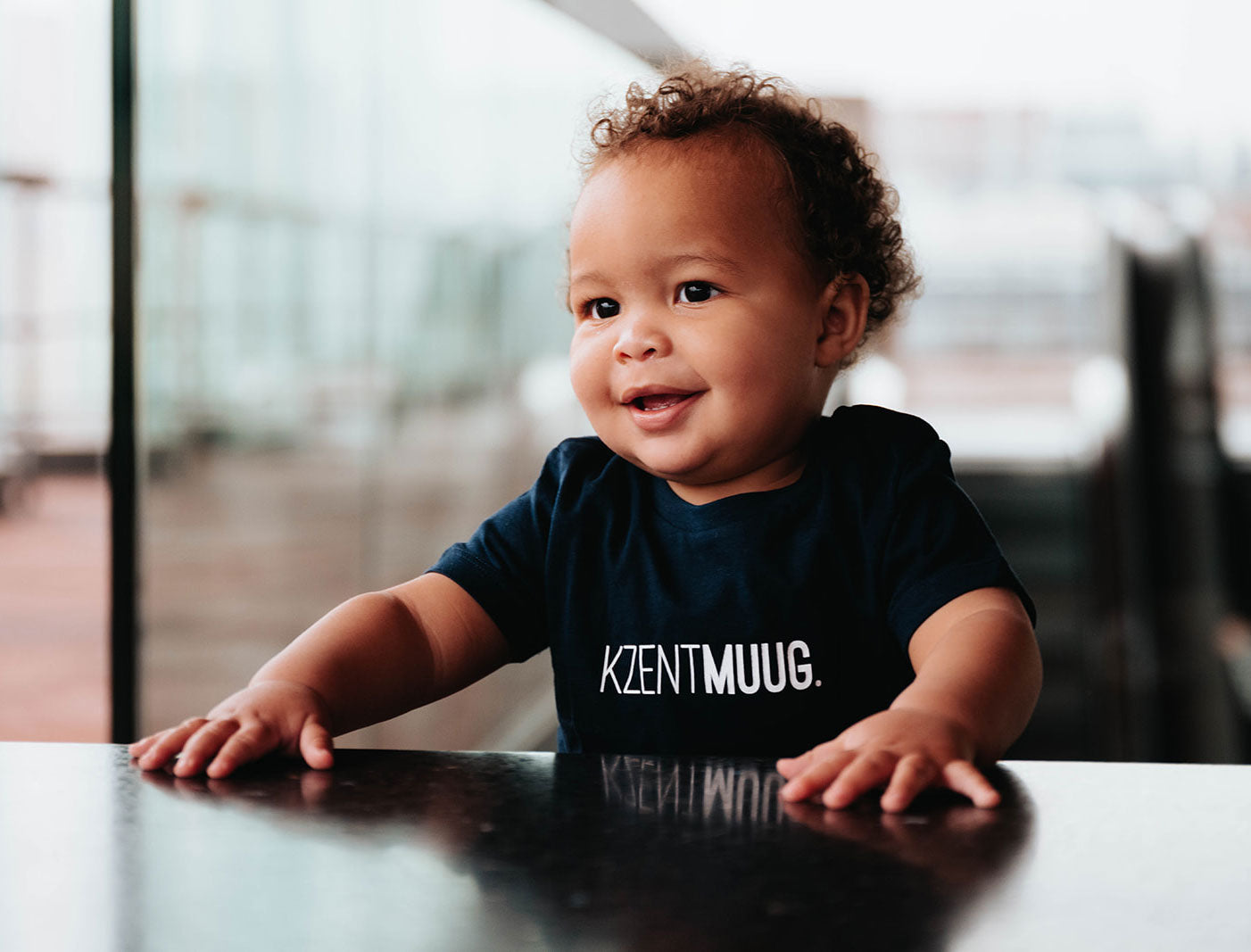 Baby met blauwe T-shirt voor baby's met opdruk KZENTMUUG.