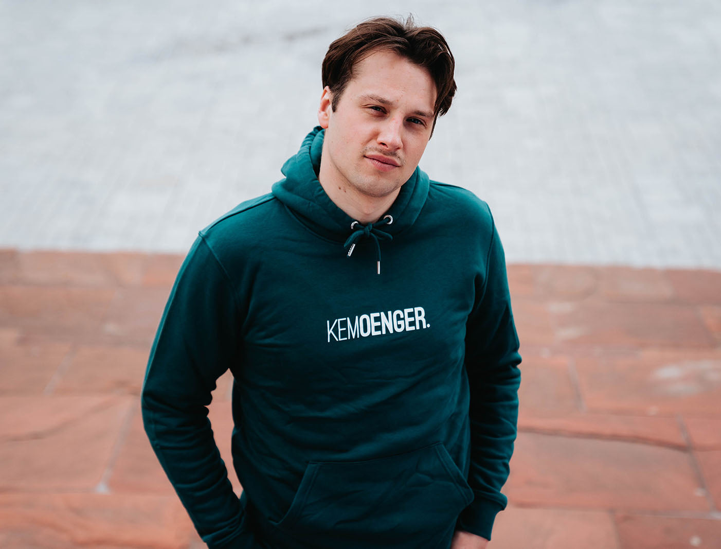 Man met groene hoodie met opdruk KEMOENGER.