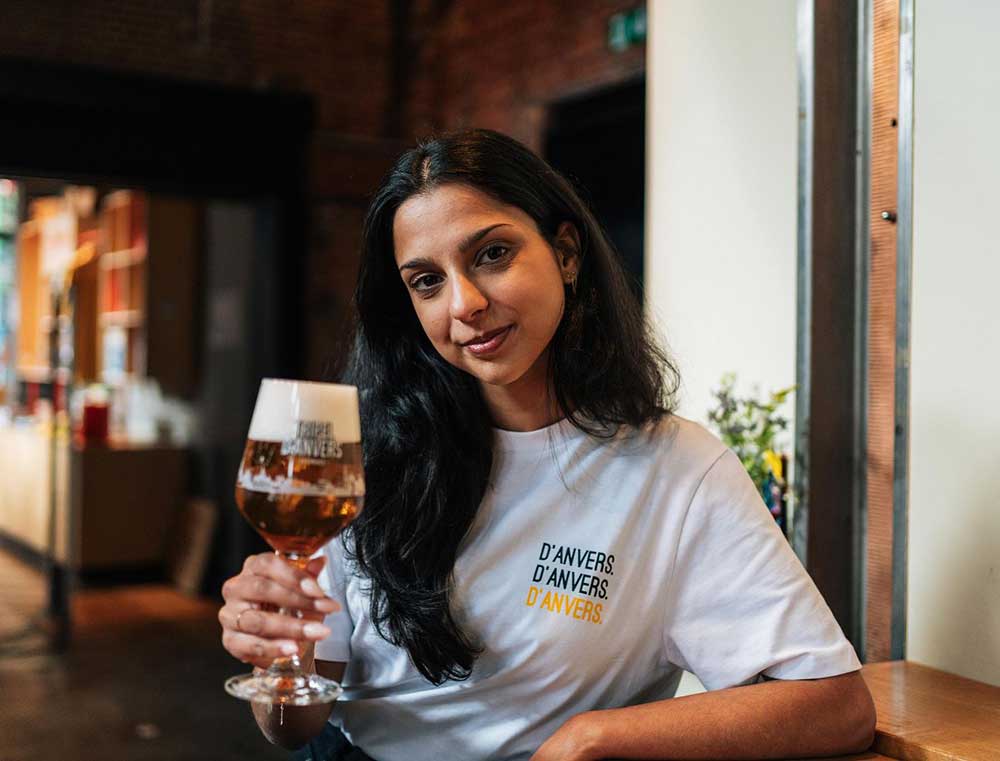 Vrouw met een witte T-shirt met opdruk d'ANVERS.