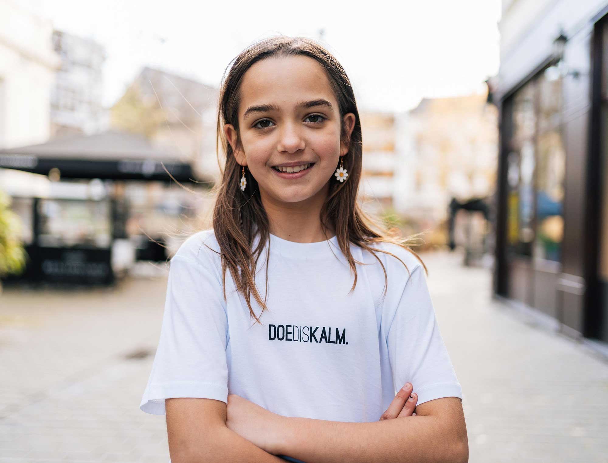 meisje met witte T-shirt met opdruk DOEDISKALM.