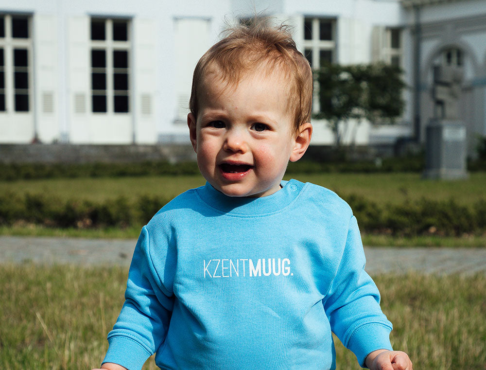 Baby met blauwe sweater met opdruk KZENTMUUG.