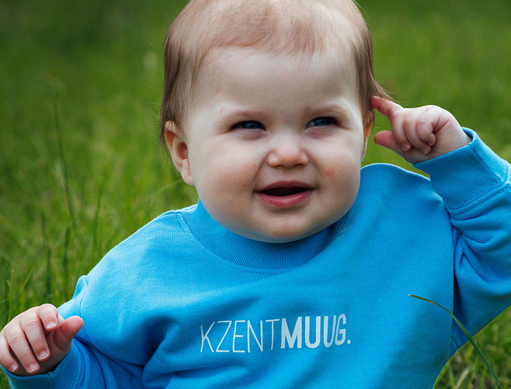Baby met blauwe sweater met opdruk KZENTMUUG.