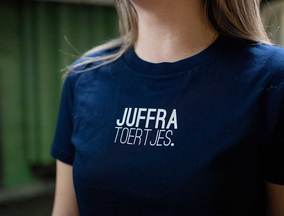 Close-up van een donkerblauwe T-shirt met opdruk JUFFRA TOERTJES.