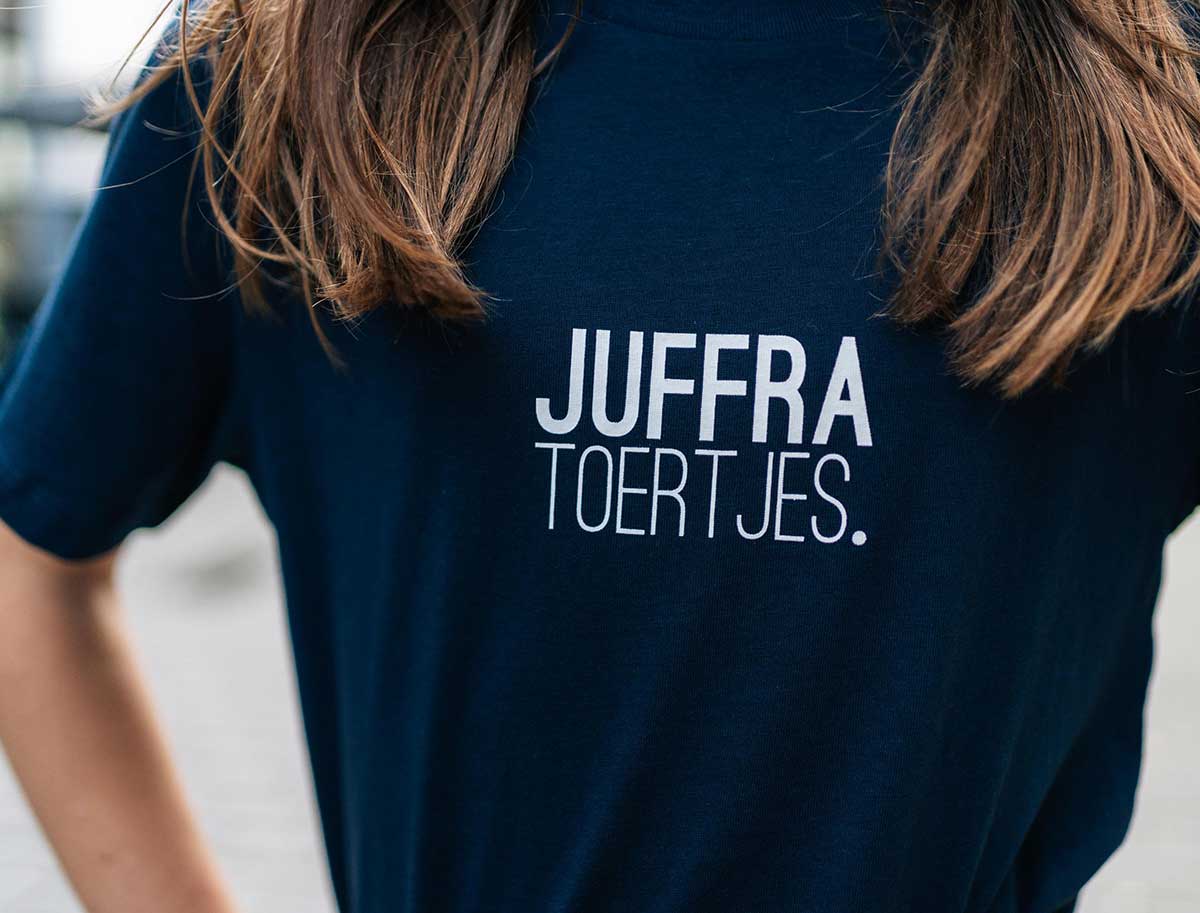 Close-up van een donkerblauwe T-shirt met opdruk JUFFRATOERTJES. voor kinderen