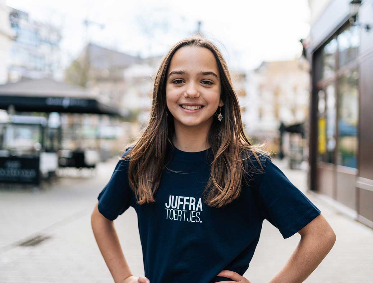 Meisje met een donkerblauwe T-shirt met opdruk JUFFRATOERTJES. voor kinderen