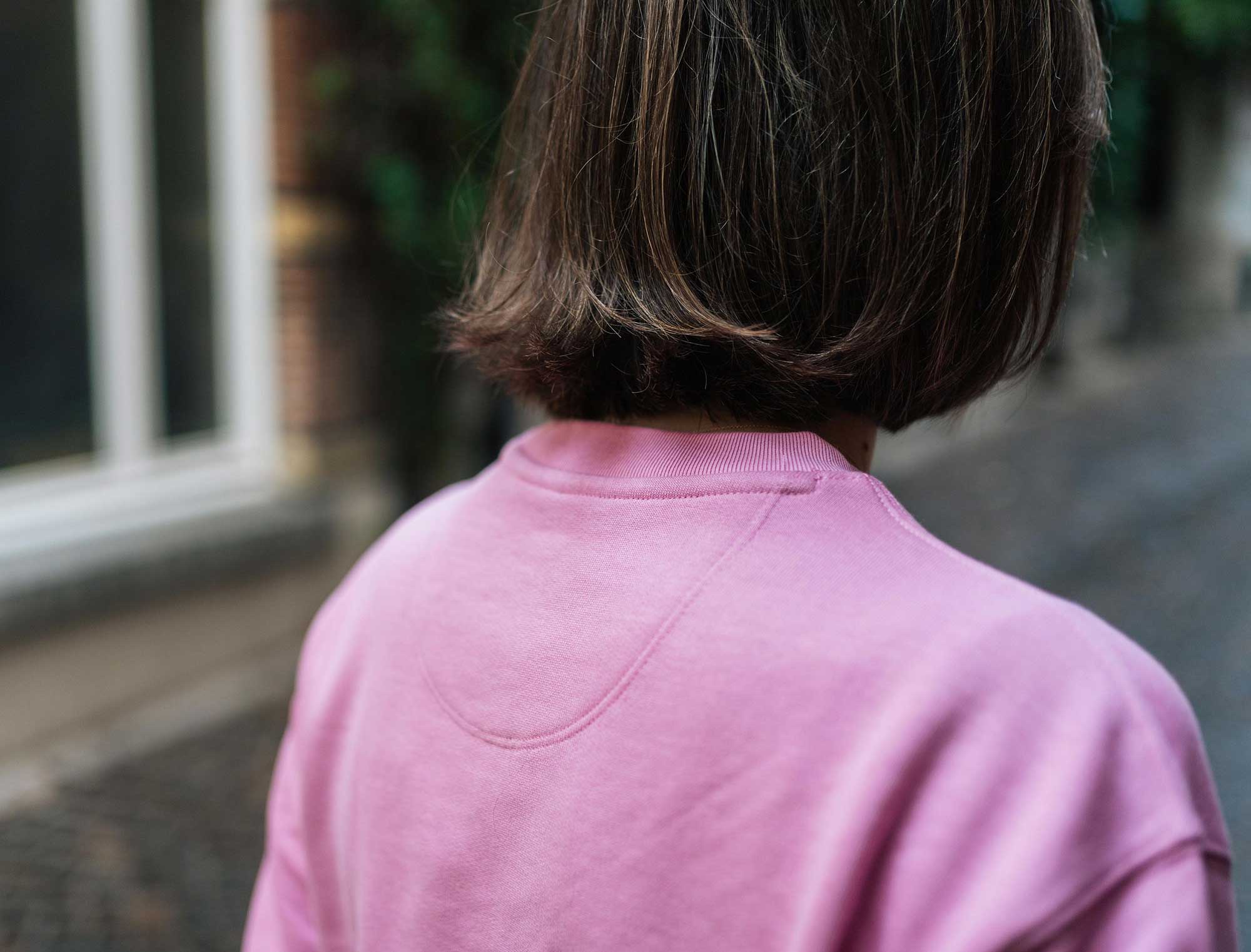 Achterkant van een roze sweater met opdruk JUFFRA TOERTJES.