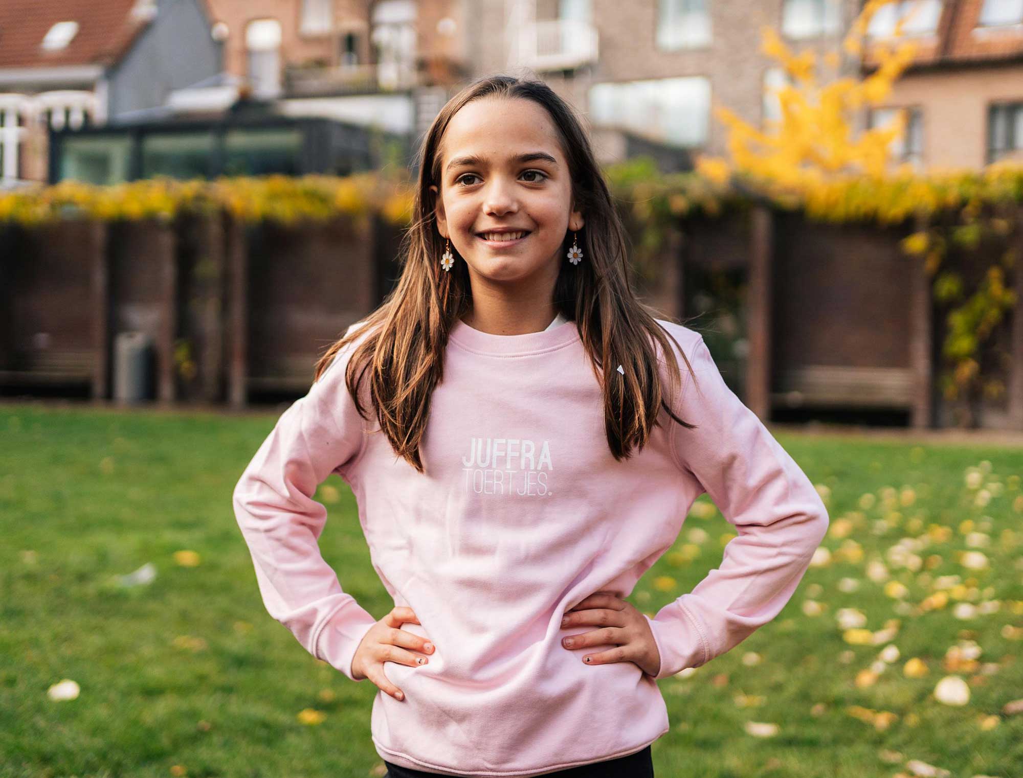 Meisje met een roze sweater met opdruk JUFFRA TOERTJES. voor kinderen