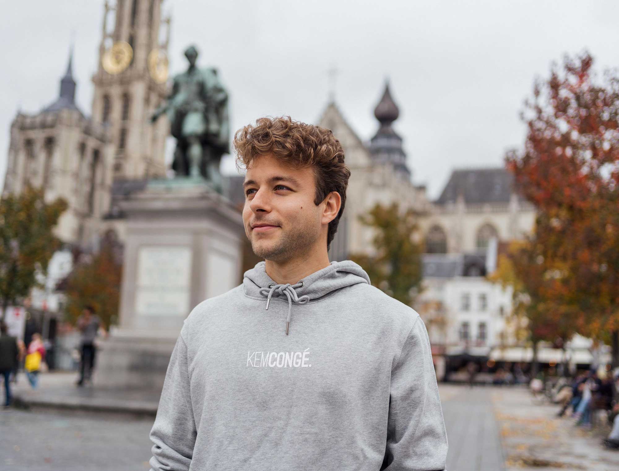 Man met een grijze hoodie met opdruk KEMCONGE.