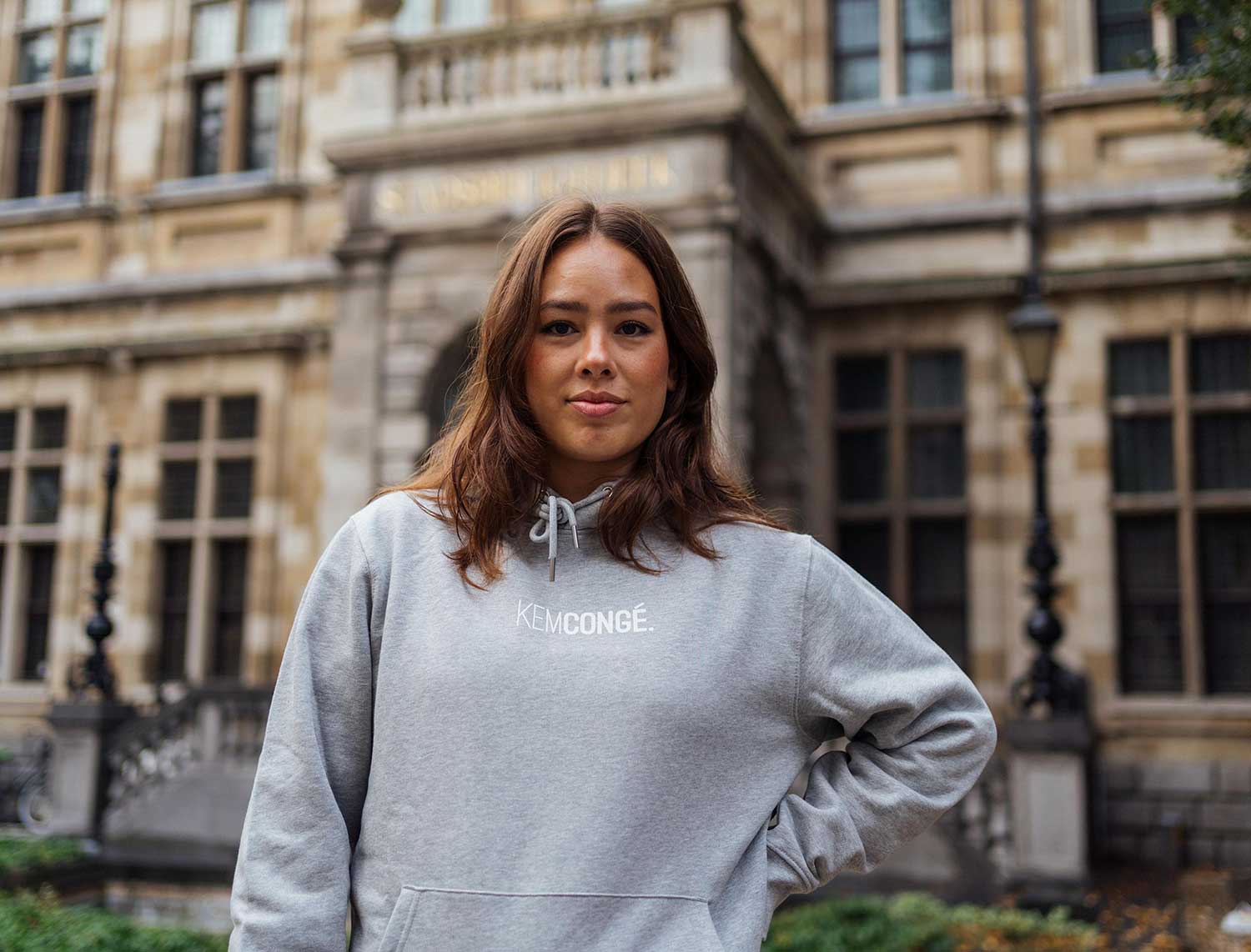 Vrouw met een grijze hoodie met opdruk KEMCONGE.