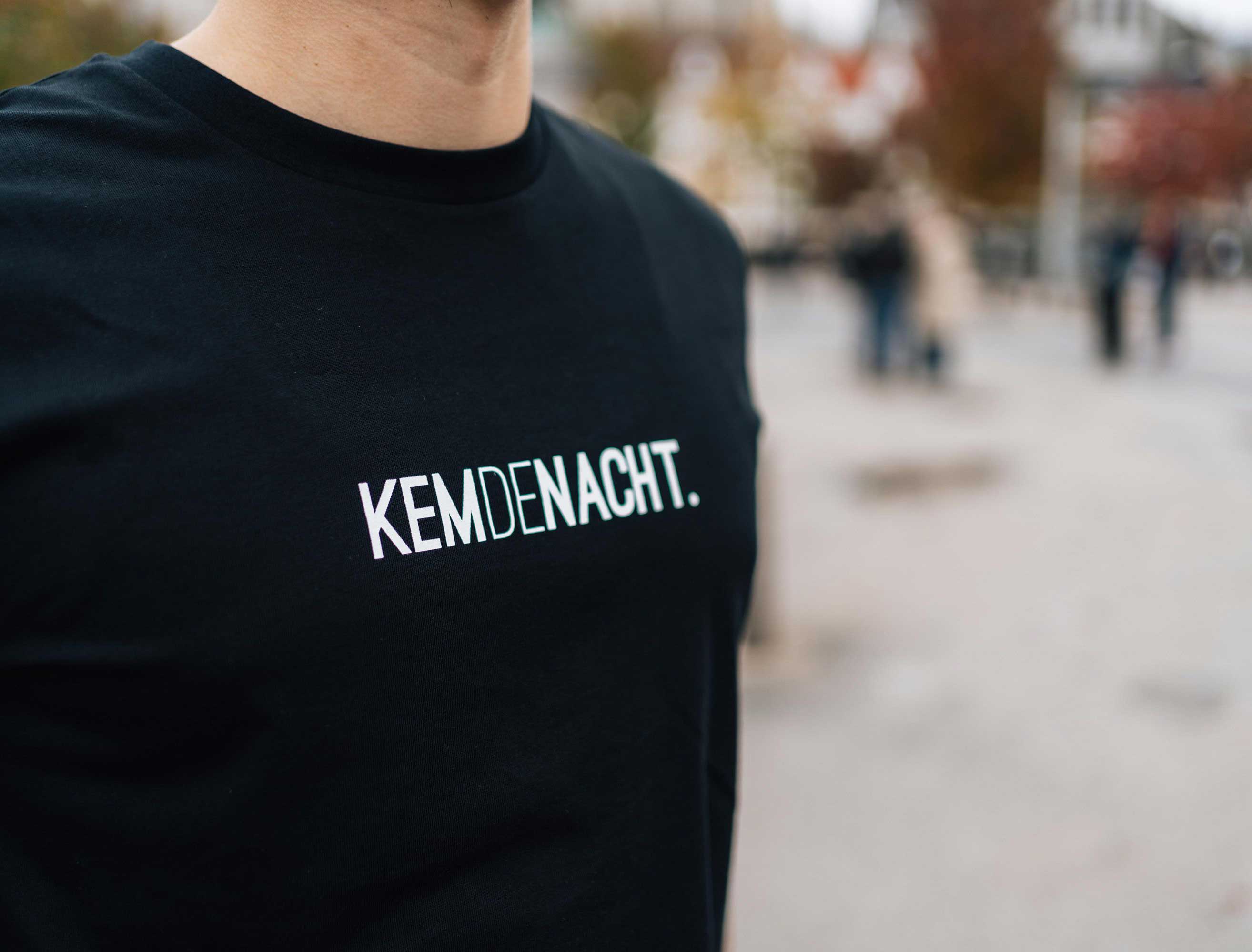 Close-up van een zwarte T-shirt met opdruk KEMDENACHT.