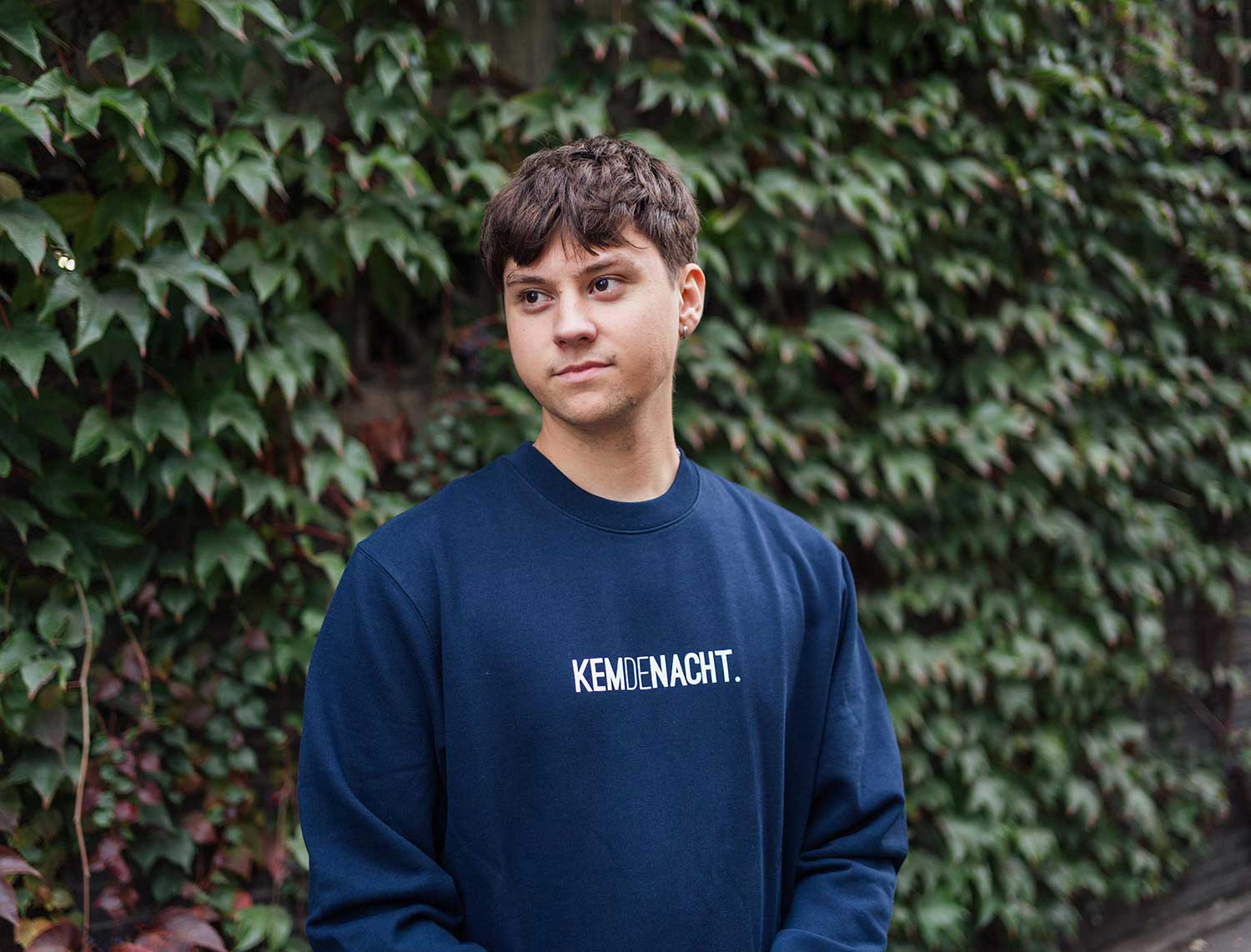 Man met een donkerblauwe sweater met opdruk KEMDENACHT.
