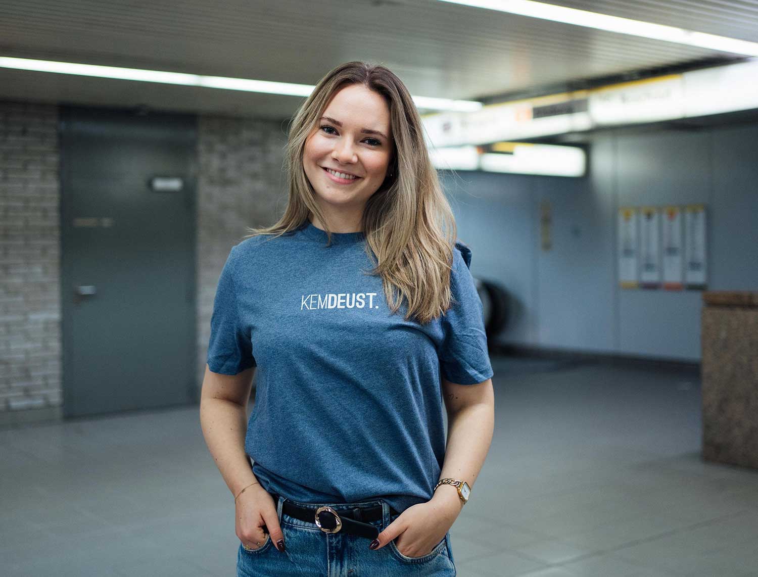 Vrouw met een blauwe T-shirt met opdruk KEMDEUST.