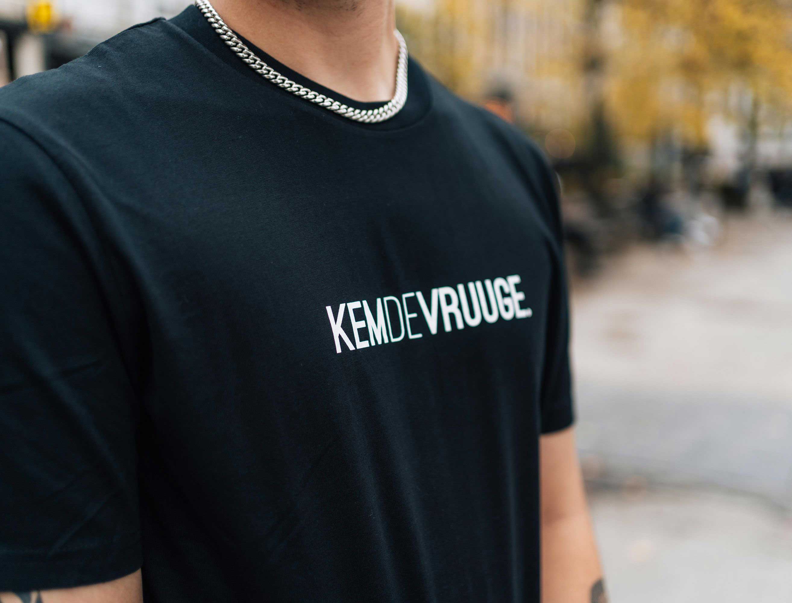 Close-up van een zwarte T-shirt met opdruk KEMDEVRUUGE.