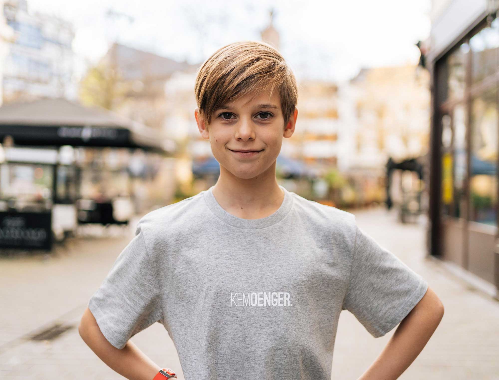jongen met grijze T-shirt met opdruk KEMOENGER.