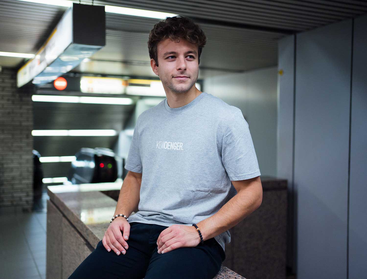 Man met een grijze T-shirt met opdruk KEMOENGER.