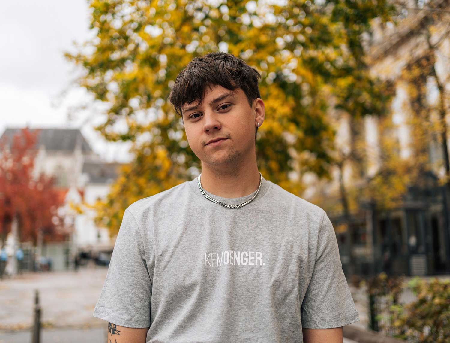 Man met een grijze T-shirt met opdruk KEMOENGER.