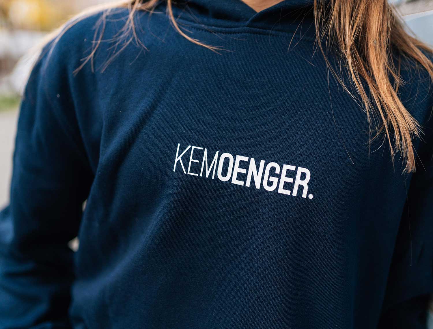 Close-up van blauwe hoodie met opdruk KEMOENGER.