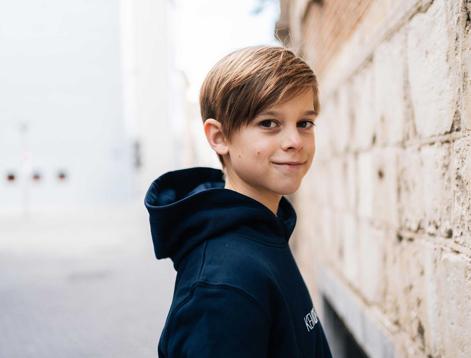 Jongen met blauwe hoodie met opdruk KEMOENGER.
