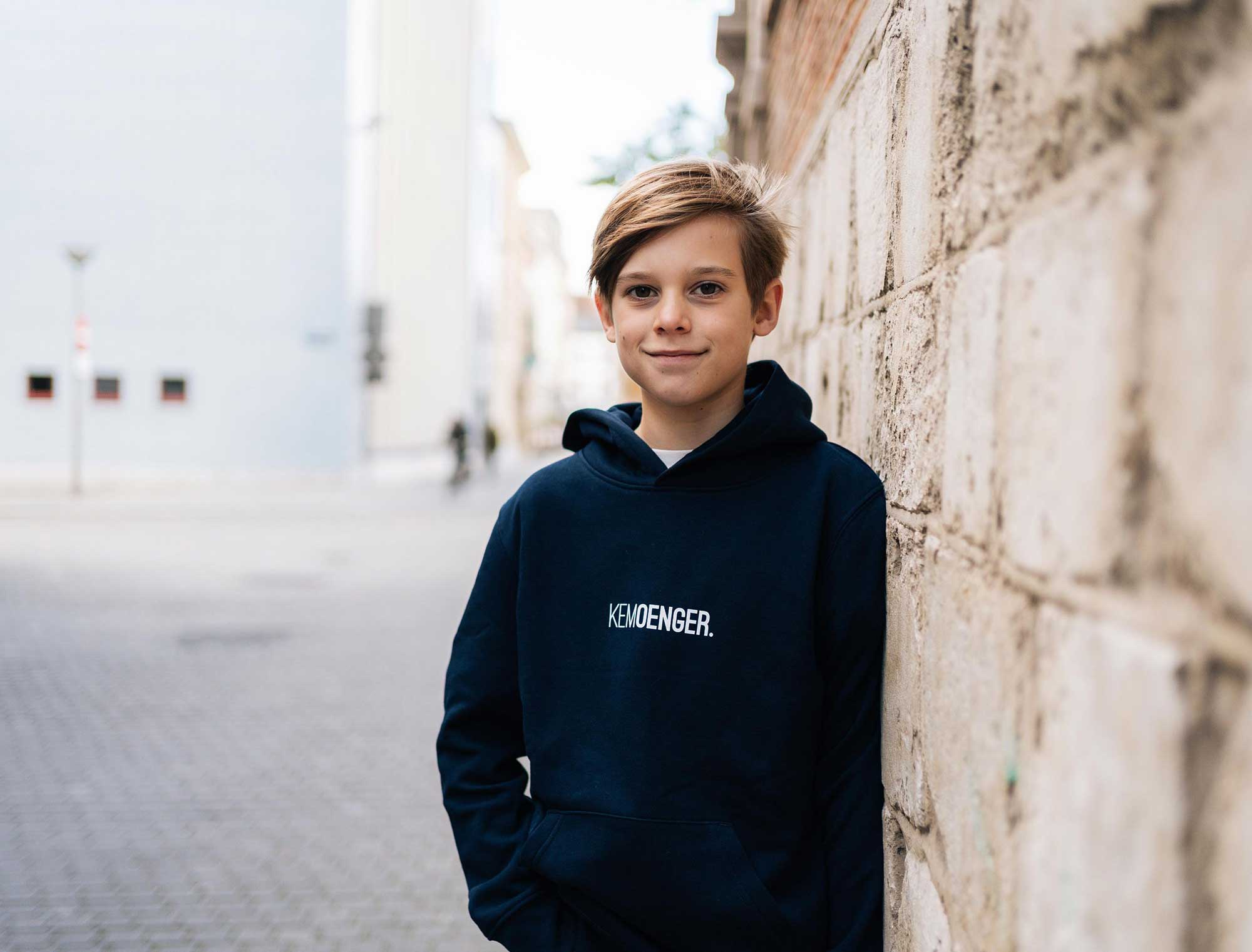 Jongen met blauwe hoodie met opdruk KEMOENGER.