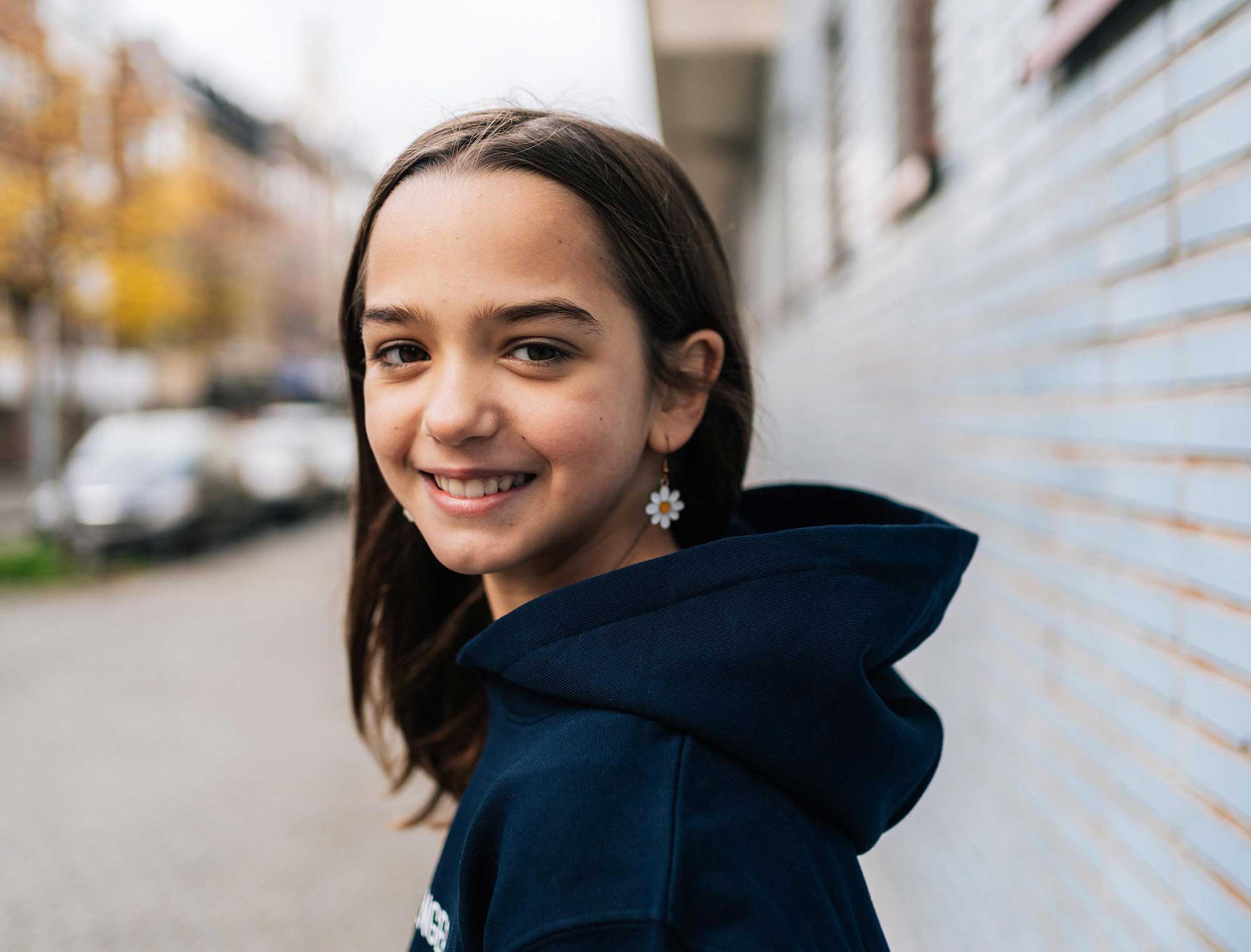 Meisje met donkerblauwe hoodie met opdruk KEMOENGER.