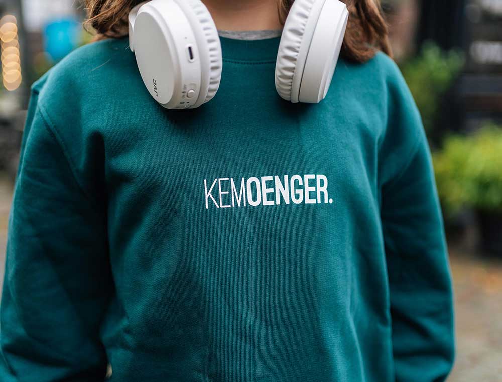 Close-up van een groene sweater voor kinderen met opdruk KEMOENGER.
