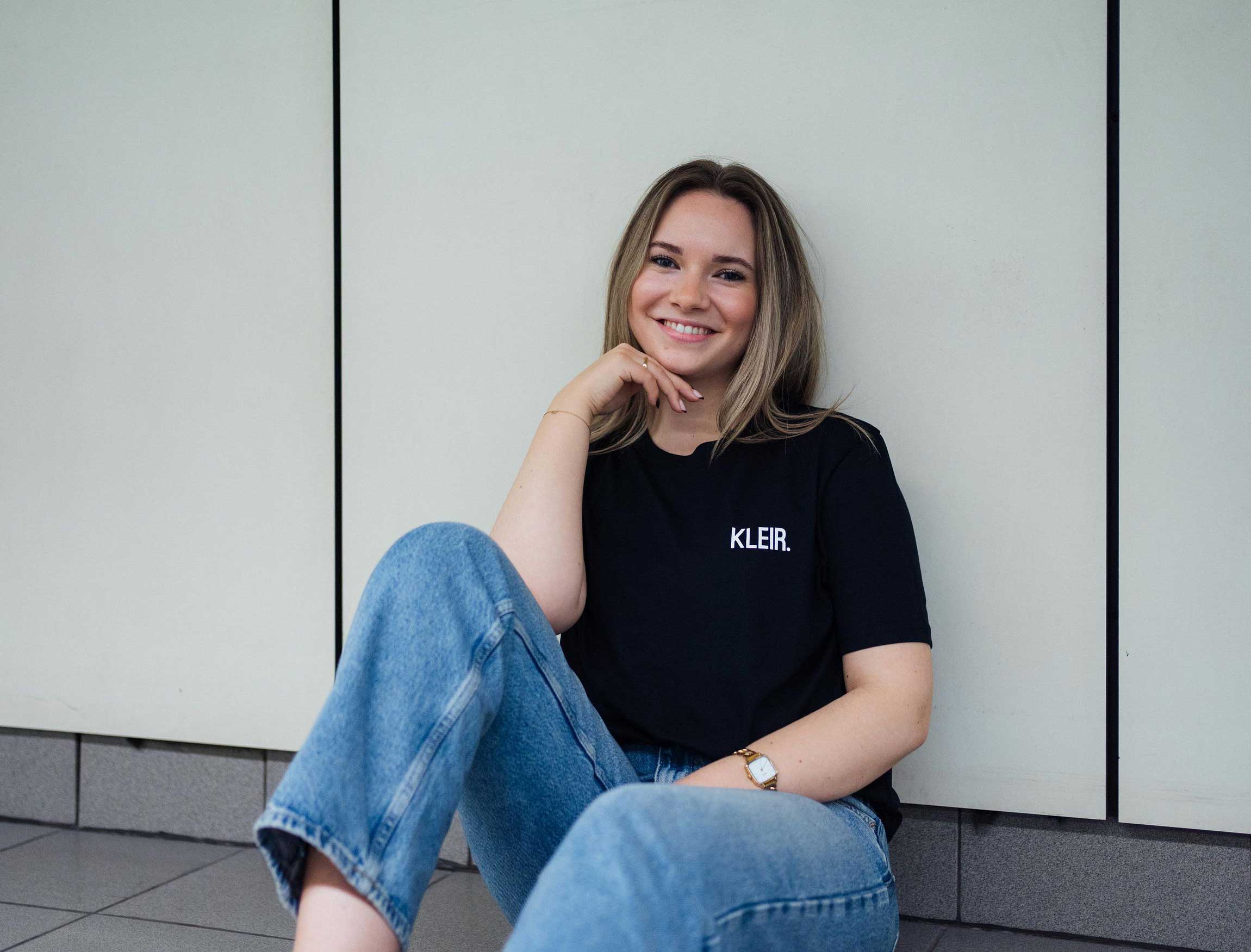 Vrouw met een zwarte T-shirt met opdruk KLEIR.
