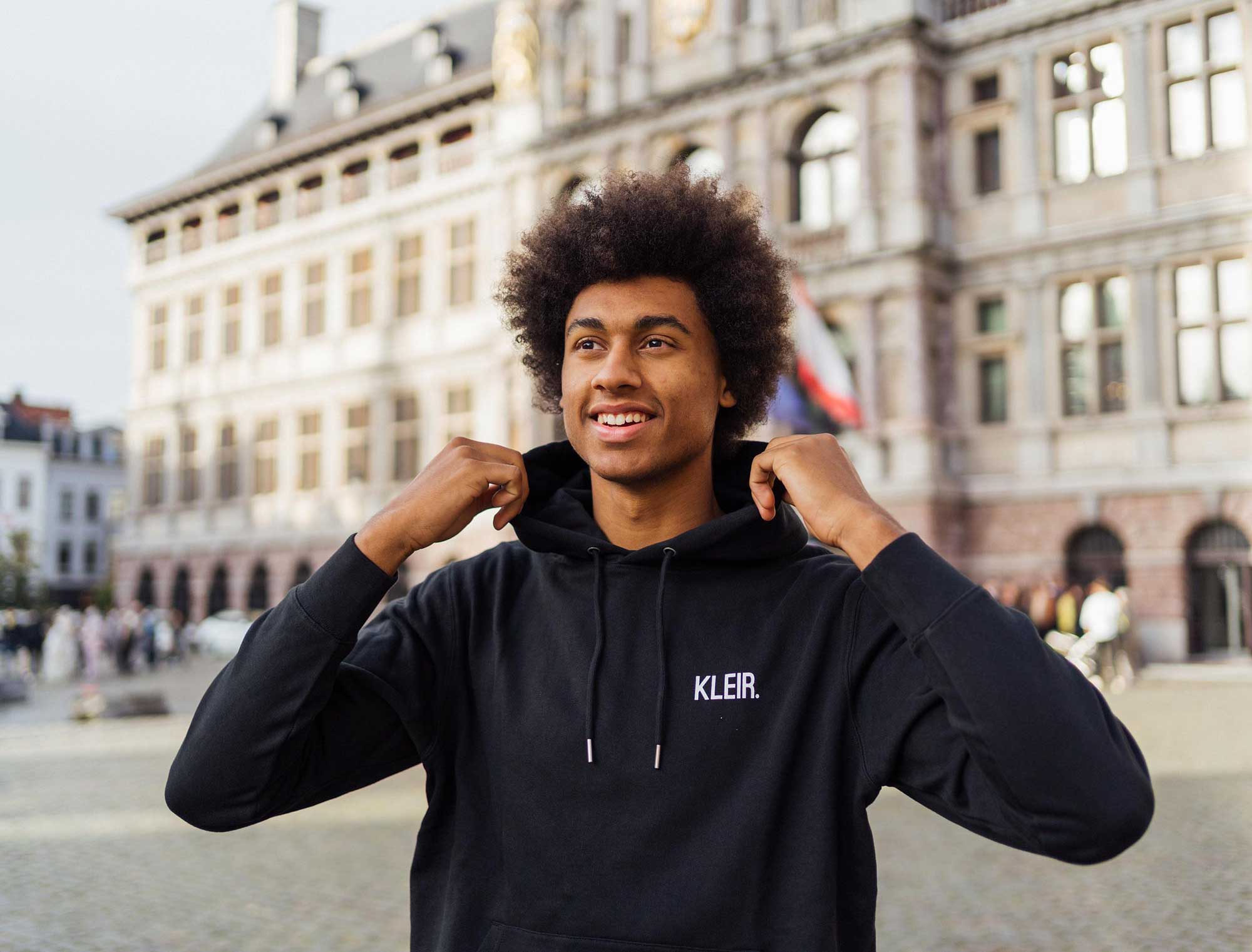 Man met een zwarte hoodie met opdruk KLEIR.