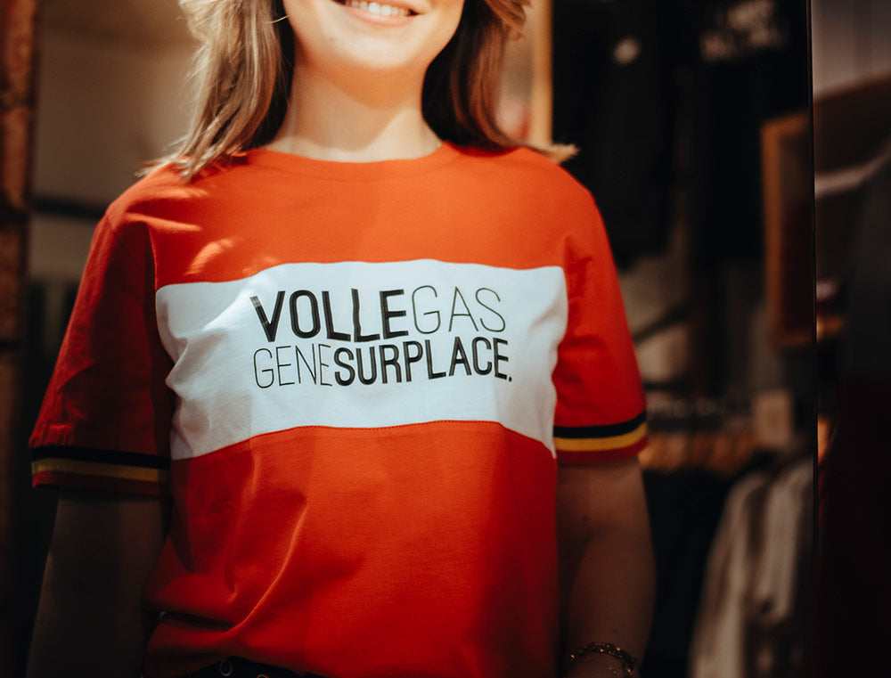 Close-up van rode T-shirt met opdruk VOLLEGAS GENE SURPLACE. 